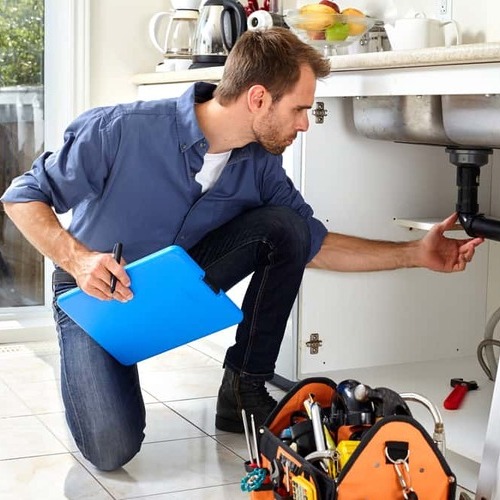 A residential plumber checks a kitchen sink